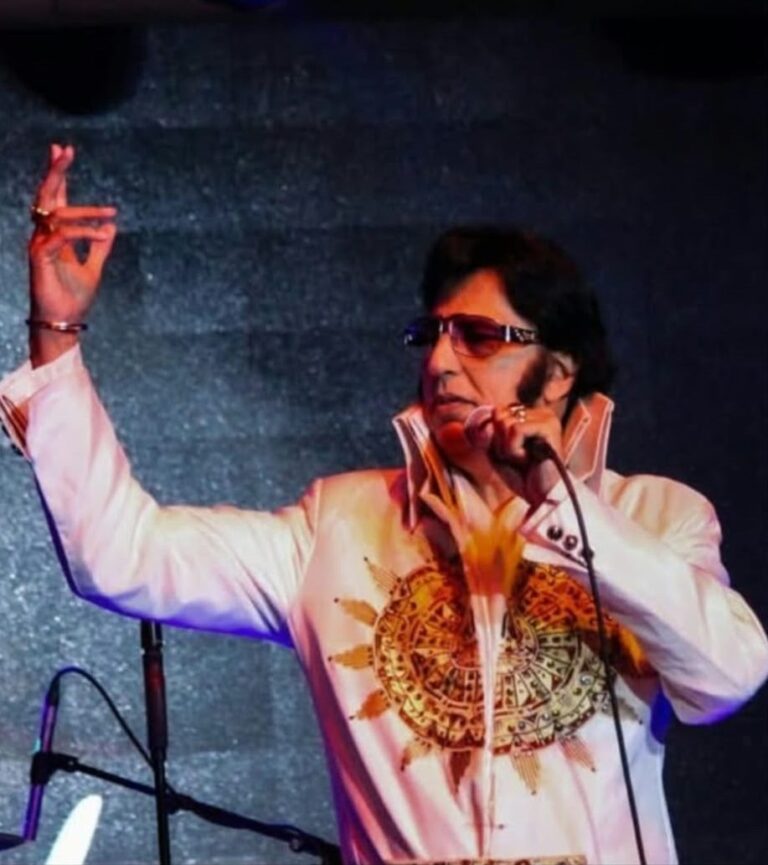 Bal Johal performing in the white sun jumpsuit